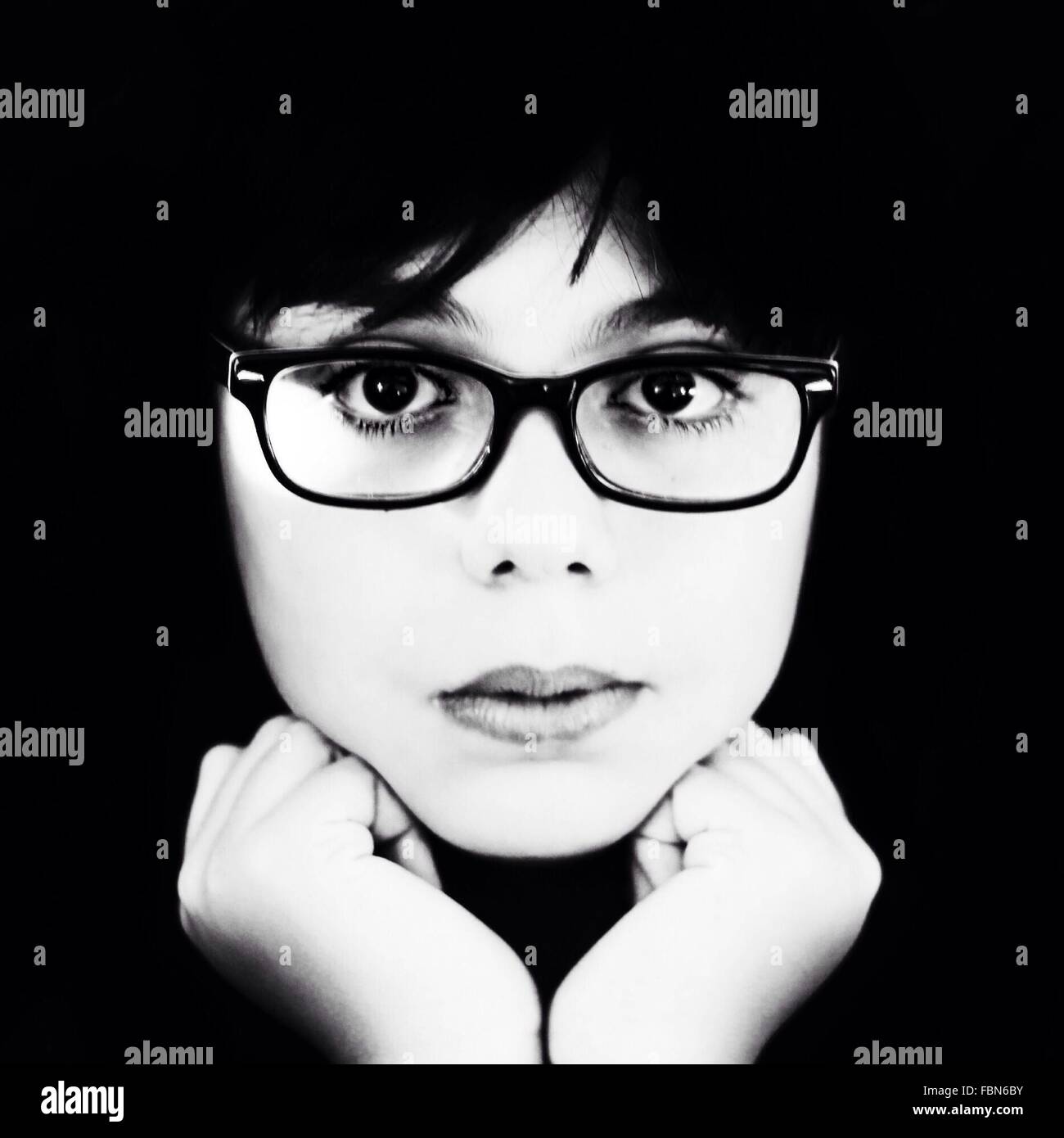 Close-Up Portrait Of Young Woman Wearing Eyeglasses Over Black Background Stock Photo