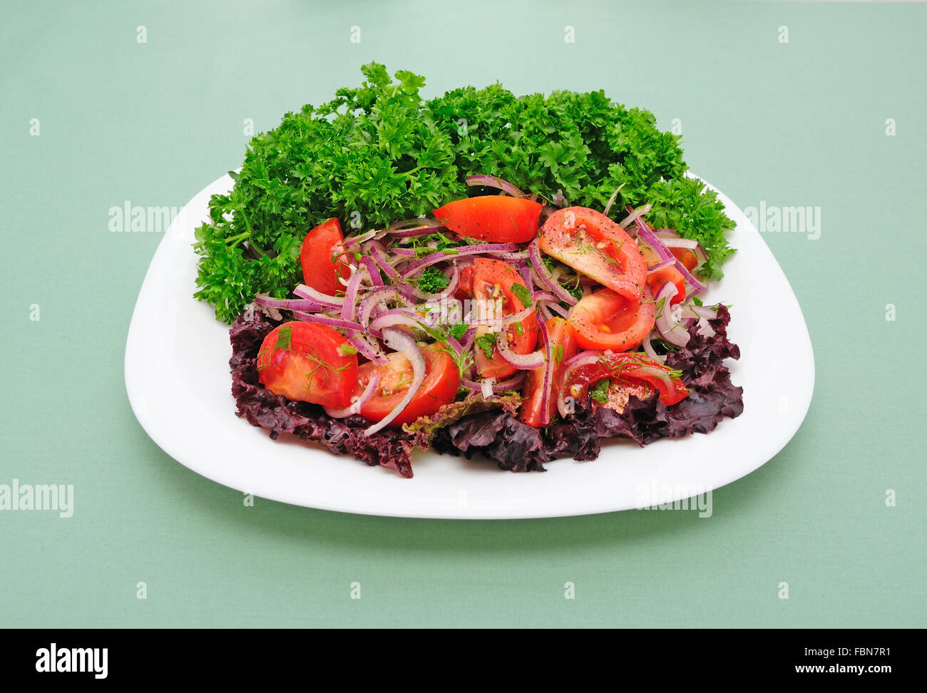 Salad of tomato with sharp blue onion and parsley Stock Photo