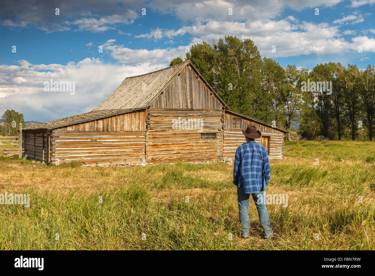 A young man by Thomas Alma Moulton Barn, Antelope Flats, Grand Teton National Park, Wyoming, USA. Stock Photo