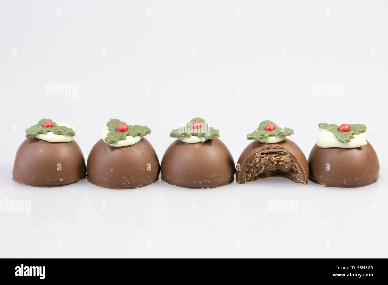 Chocolate christmas puddings on a white background. Stock Photo