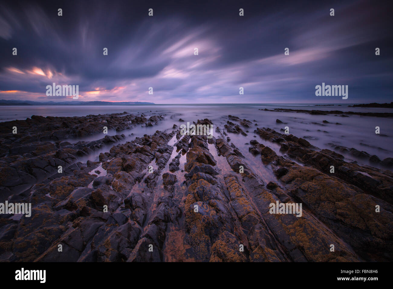 The rocks in La Vega Beach by twilight. Vega, near Ribadesella, Asturias, Spain. Stock Photo