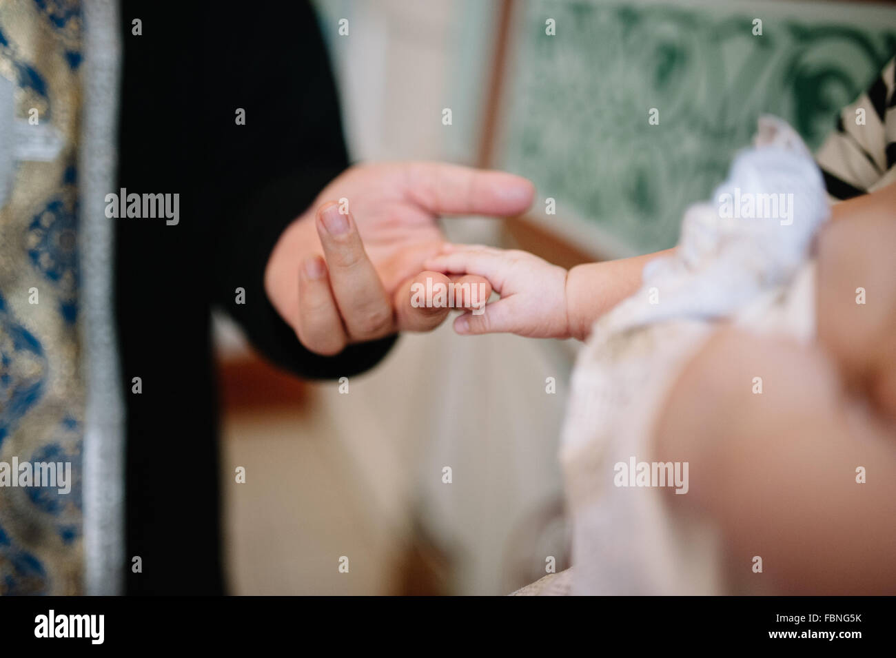 holding baby hand during christening Orthodox baptism Stock Photo
