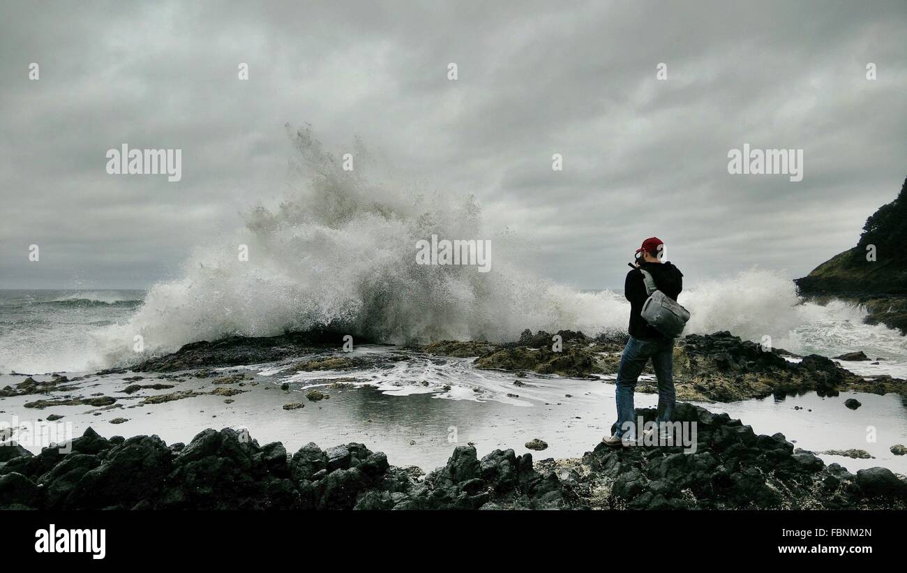 Person Watching Sea Waves Crashing On Shore Stock Photo