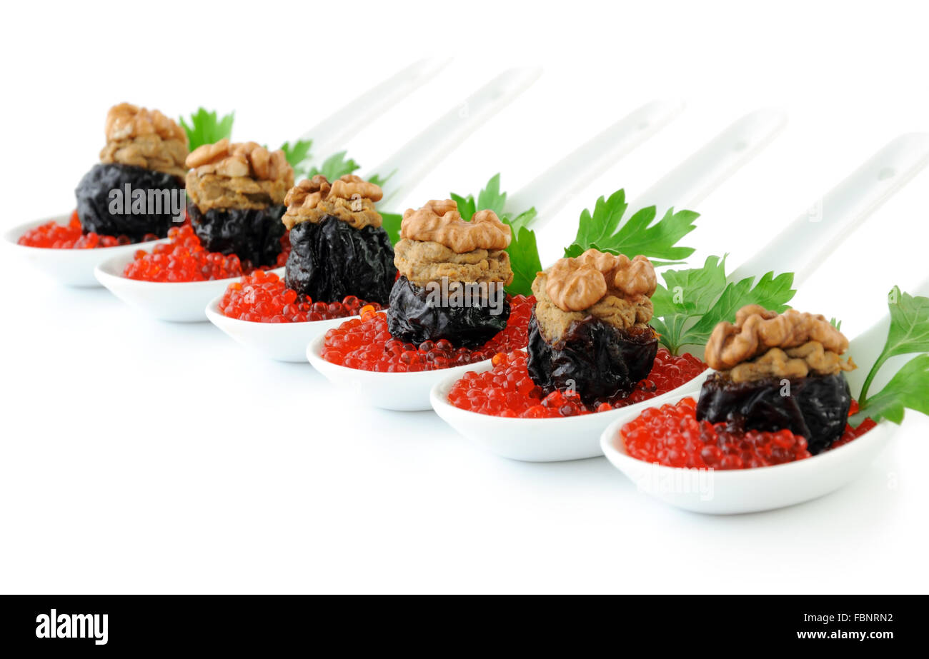 Prunes stuffed with liver pate with nuts in a red caviar Stock Photo