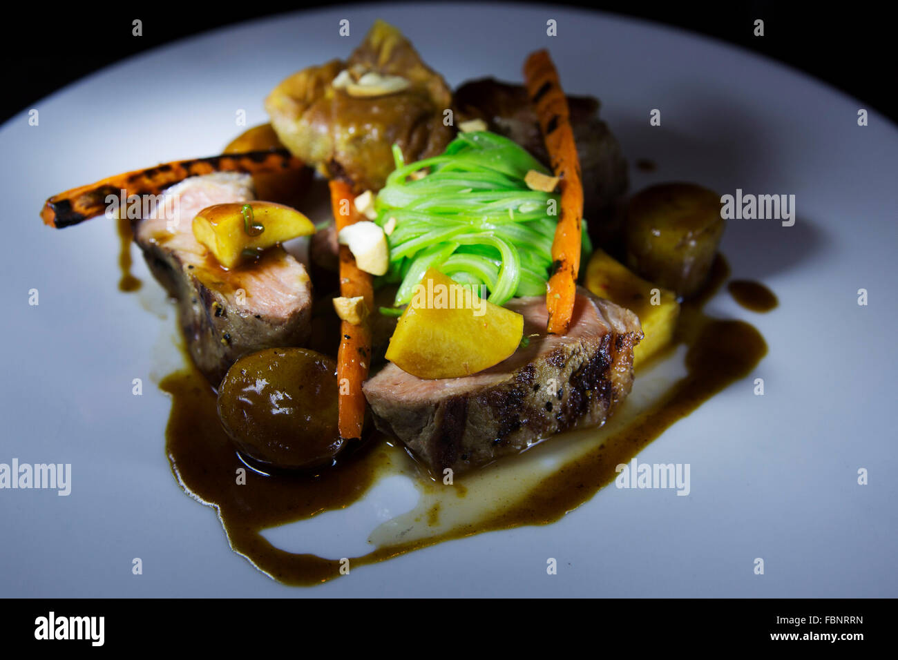 Veal served with season vegetables and jus. The meal is served in the