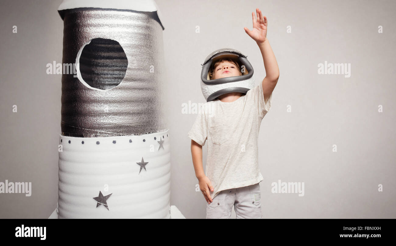 Happy child dressed in an astronaut costume playing with hand ma Stock Photo