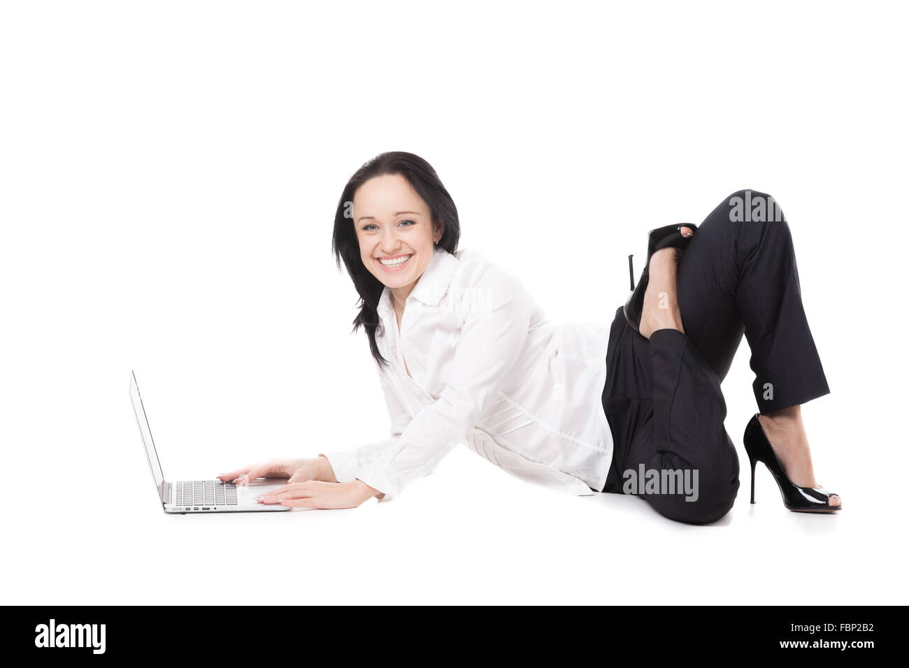 Business and healthy lifestyle. Happy smiling young female office employee in formalwear sitting in yoga posture in front Stock Photo