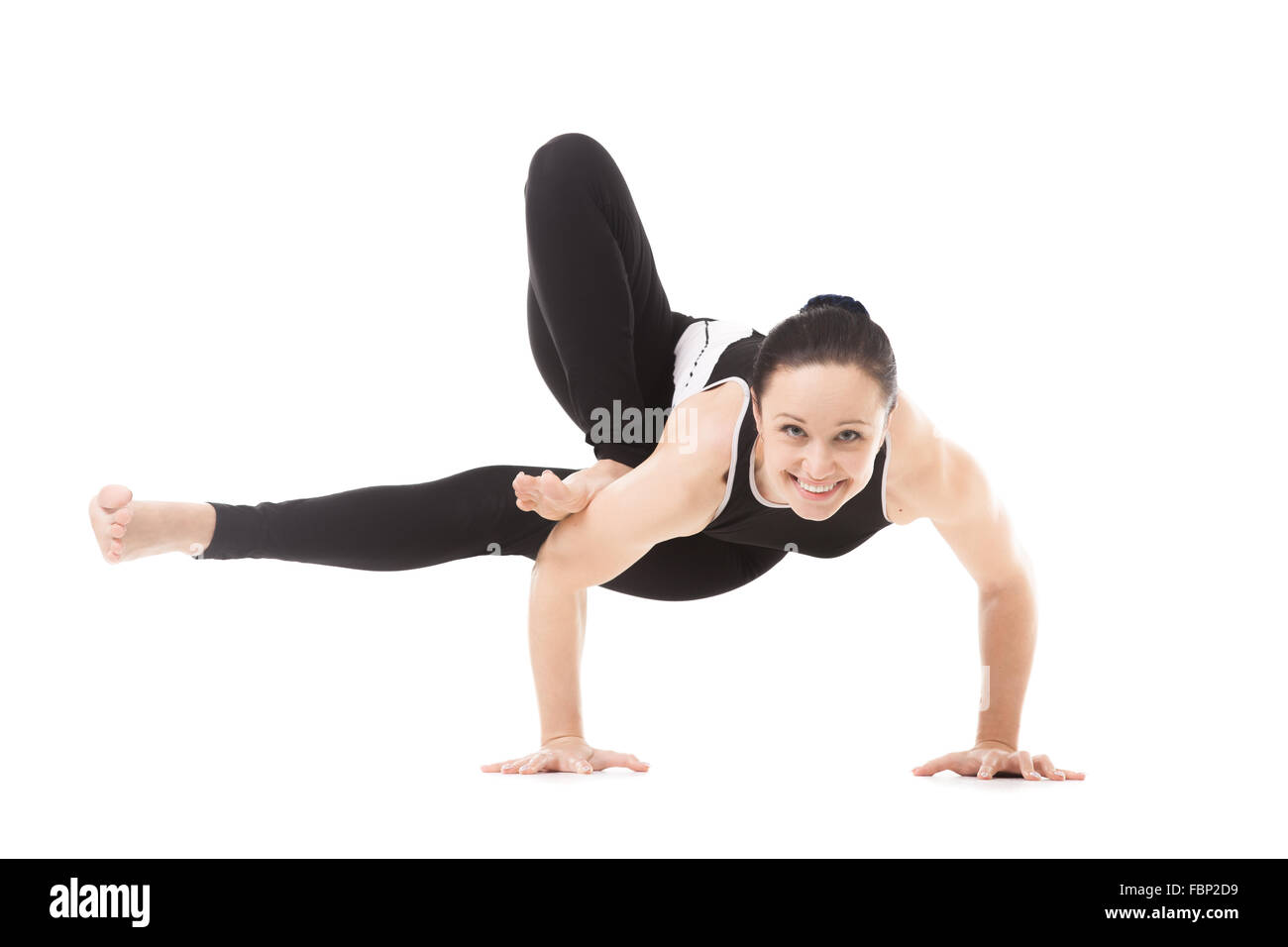 Sporty yogi girl doing exercises, asana Parivritta Eka Pada Koundinyasana, twisted one legged arm balance posture, Yoga Pose Stock Photo