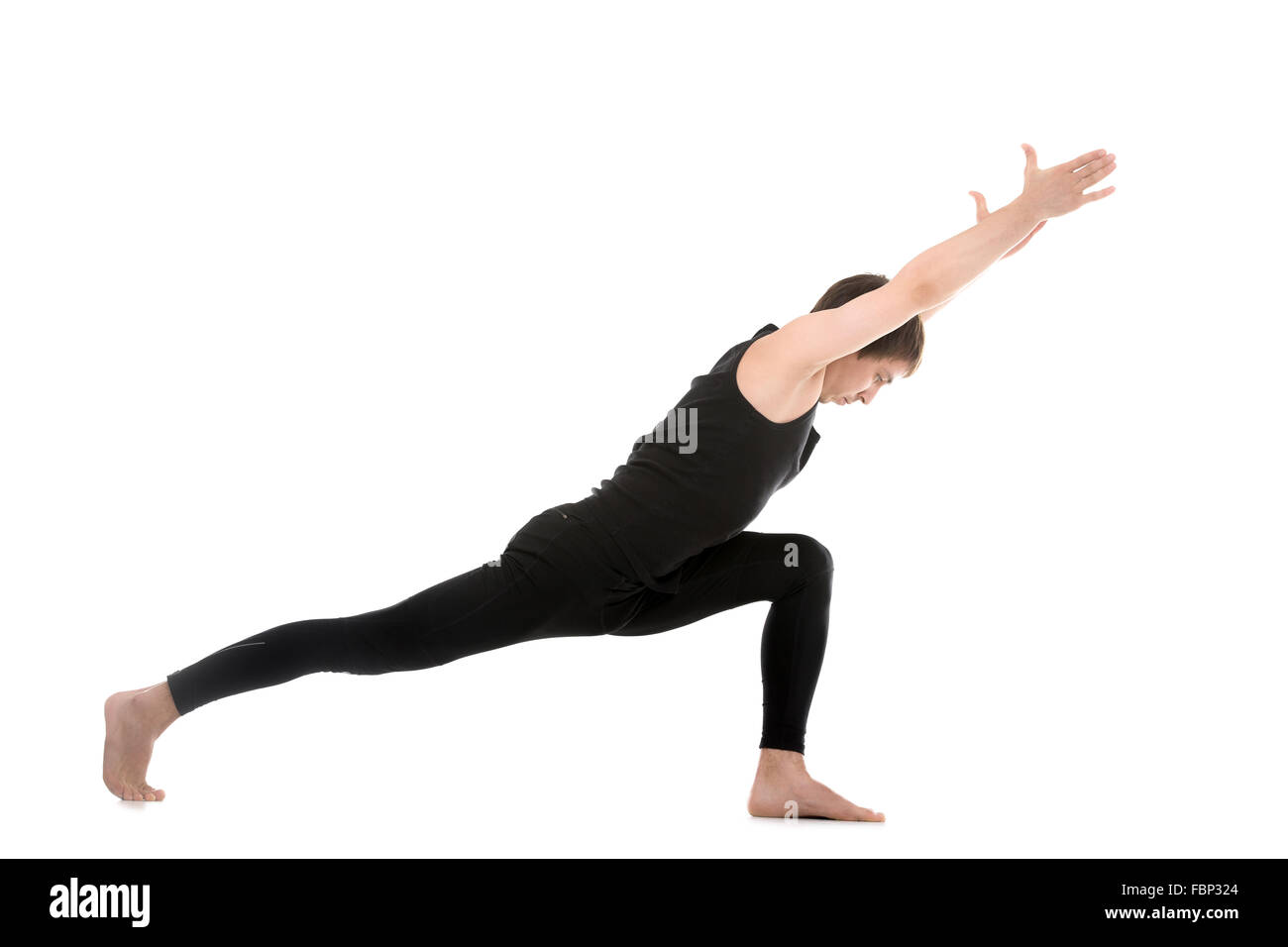 Profile of sporty yoga young man on white background doing lunge exercise, Warrior 1 posture, Virabhadrasana I Stock Photo