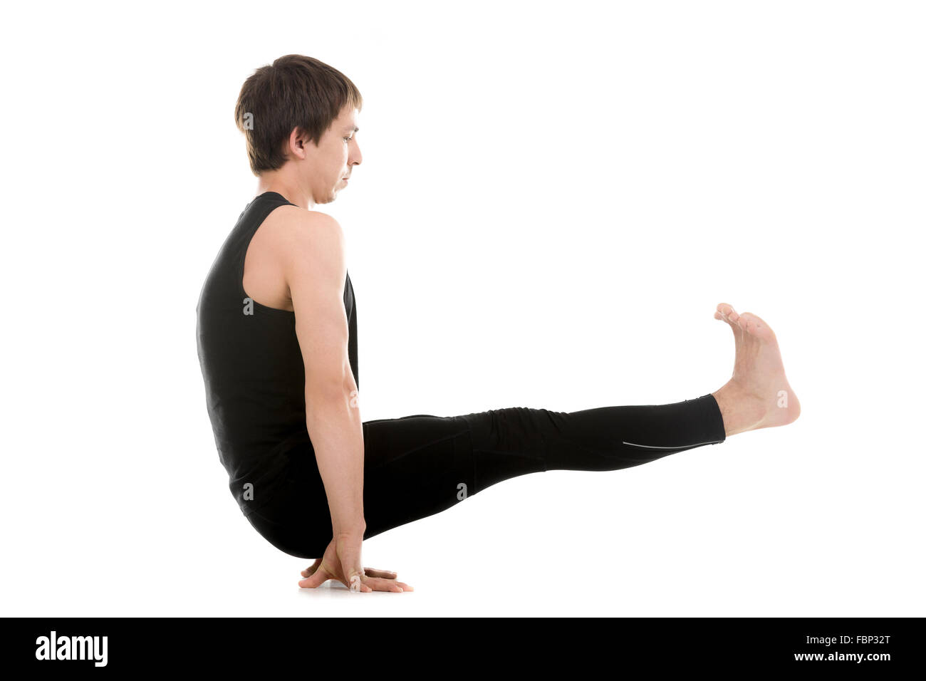 Sporty young man doing yoga or pilates arm balancing exercises, Utpluti Dandasana (Floating Stick asana), Celibates posture Stock Photo