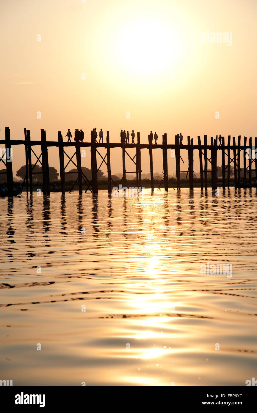 Silhouettes of people crossing the U Bein bridge in Amarapura near ...