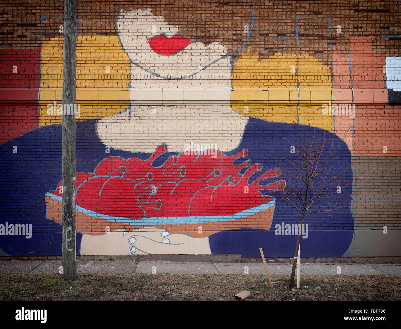 Partially completed street art depicting a woman with a bowl of hearts in Mexicantown Detroit Stock Photo