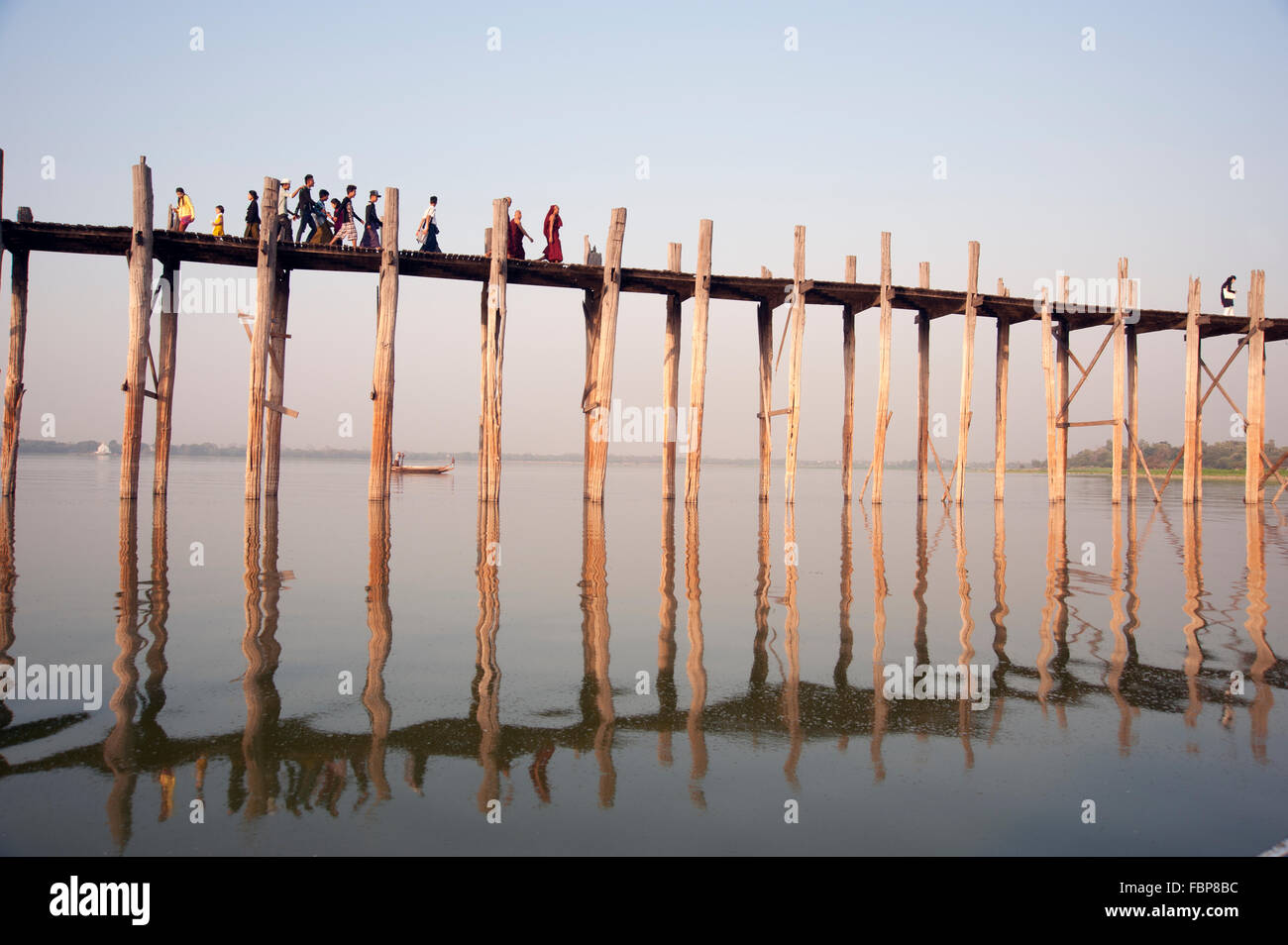 People crossing the U Bein bridge in Amarapura near Mandalay at sunset ...