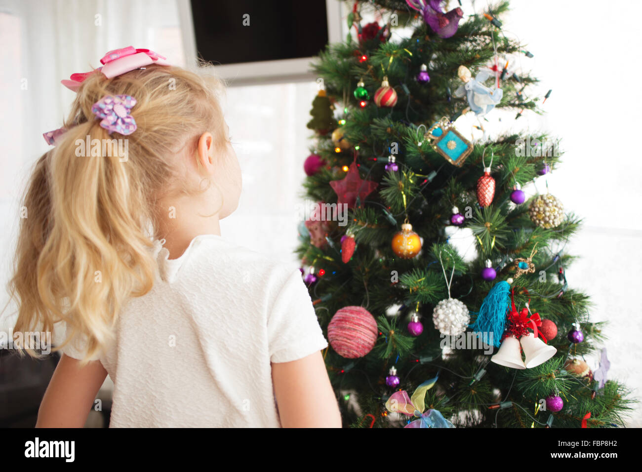 Little girl decorating Christmas tree before new year's eve Stock Photo