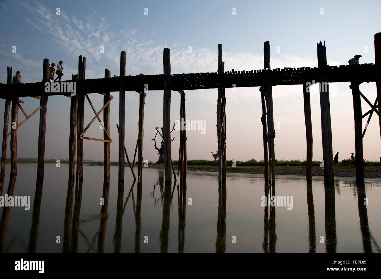 Silhouettes of people crossing the U Bein bridge in Amarapura near ...