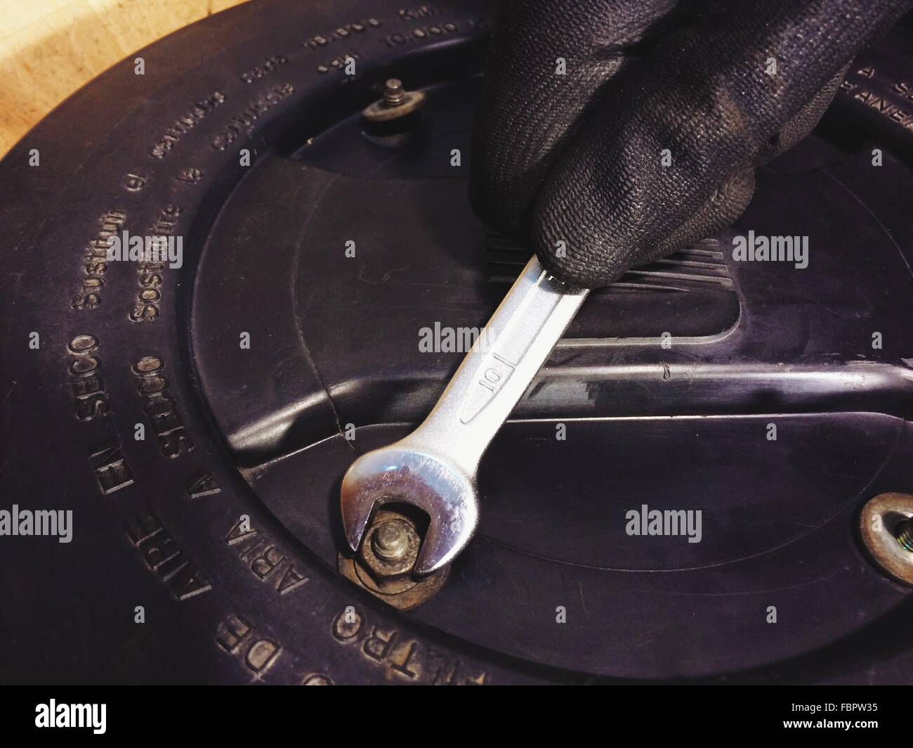 Cropped Image Of Hand Fixing Bolt With Wrench Stock Photo