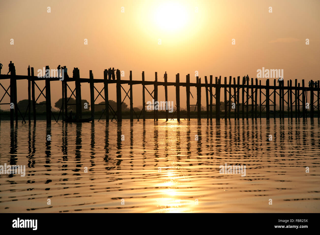 Silhouettes of people crossing the U Bein bridge in Amarapura near ...