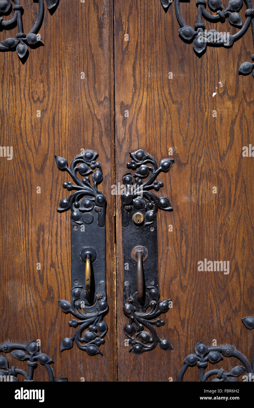 Painted brass handles on old wooden door Stock Photo