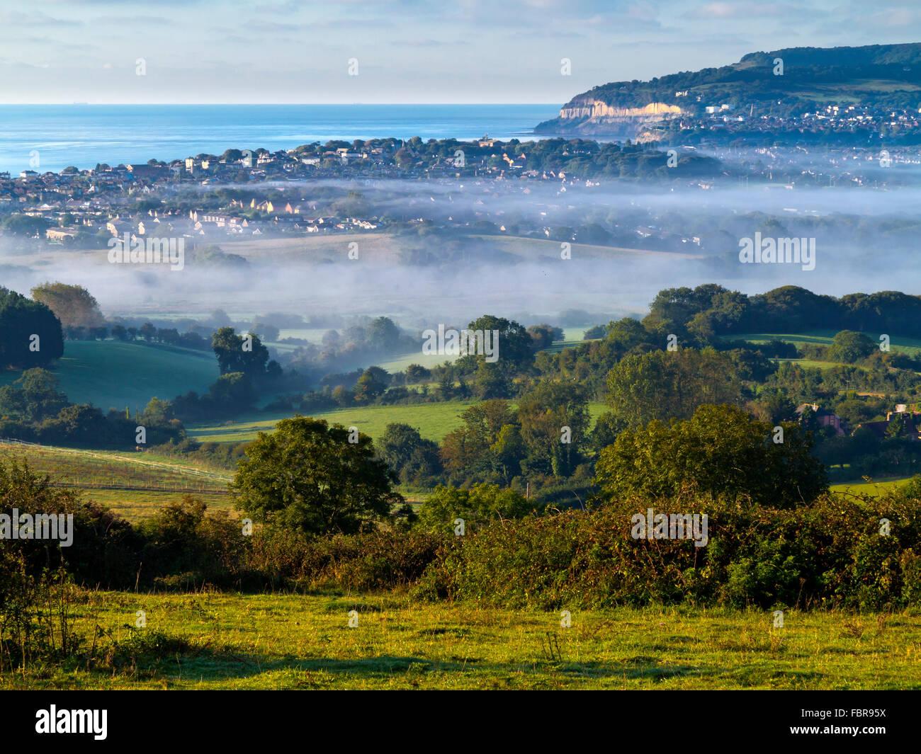 View over Brading Down on a misty summer early morning towards the east coast of the Isle of Wight in southern England UK Stock Photo