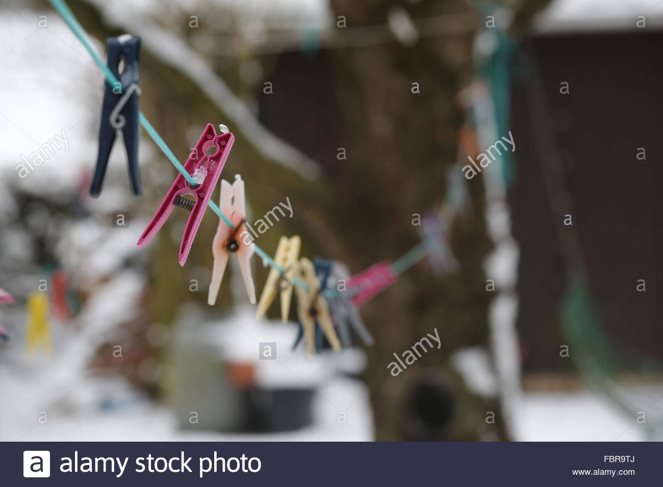 Clothes pegs in winter on a line in a German garden as temperatures drop Stock Photo