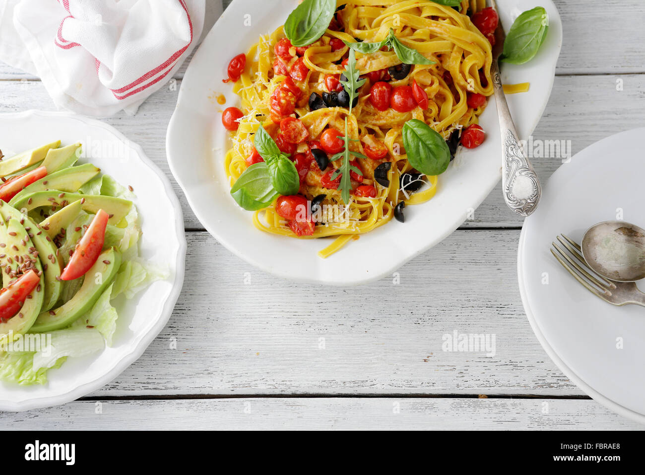 pasta and salad on wooden table, top view Stock Photo
