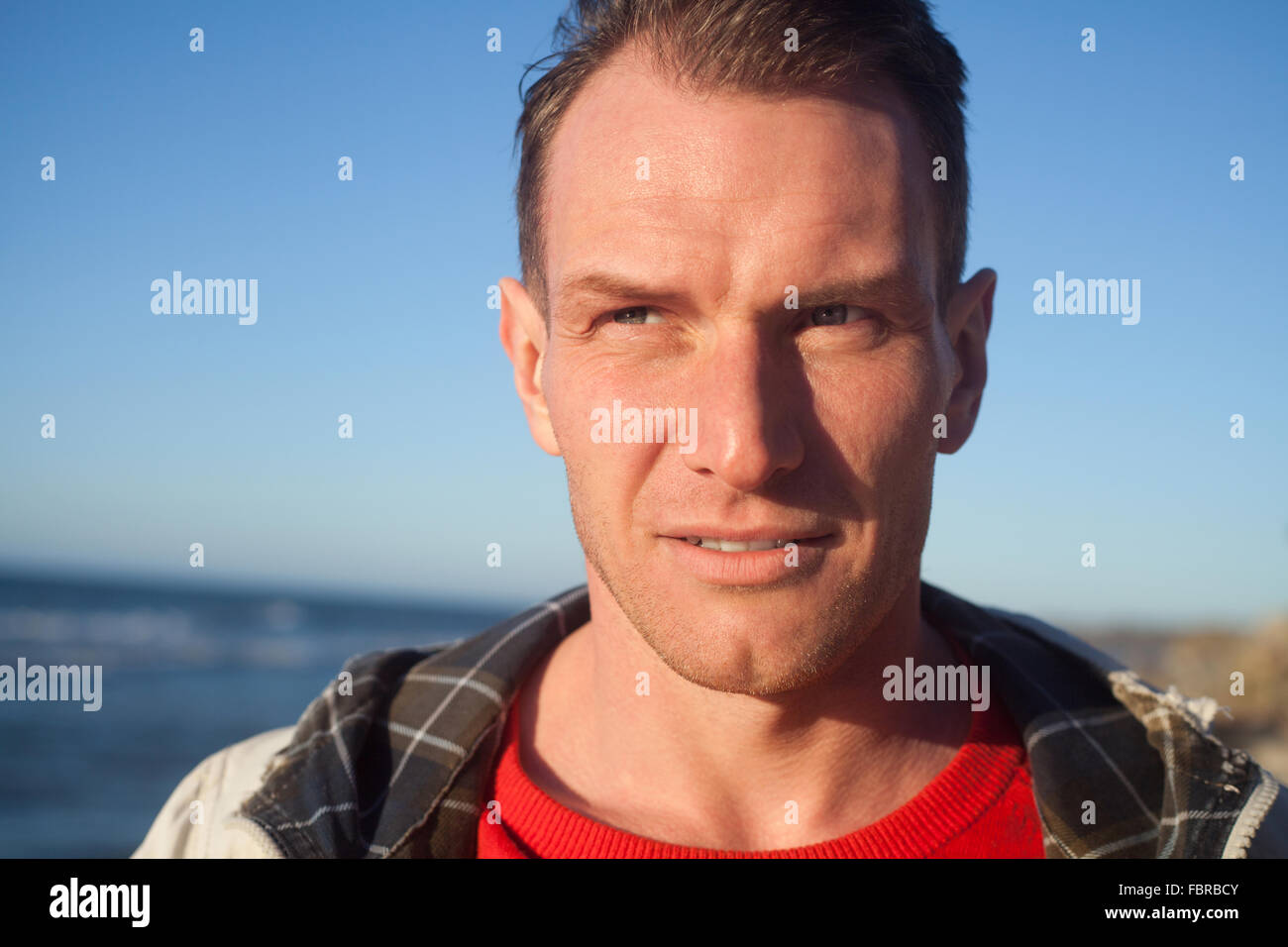Strong man portrait, sea and blue sky Stock Photo