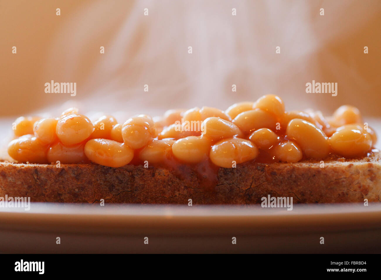 Baked beans on toast with steam rising. Stock Photo