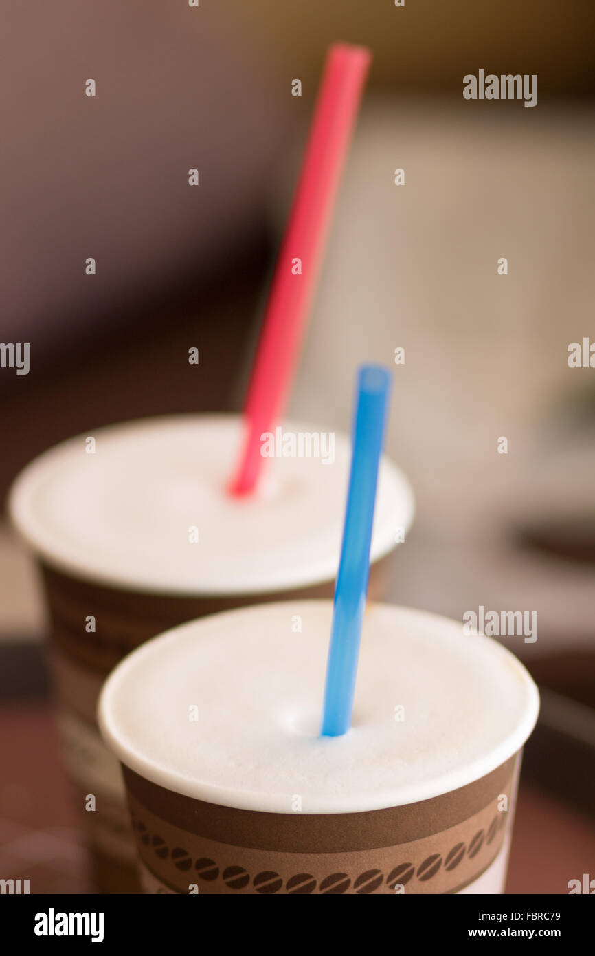 Two paper cups of cappuccino with straw. Shallow deep of field Stock Photo