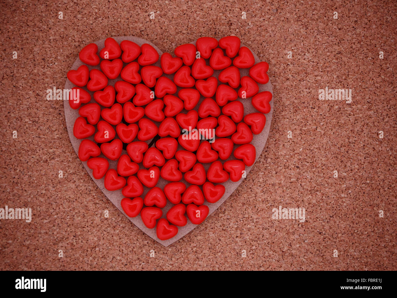 red heart shaped beads on wooden valentine Stock Photo