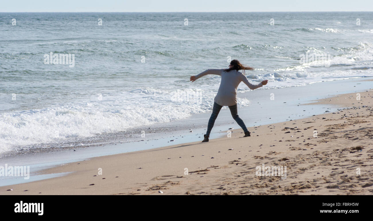 Girl skipping stones into the ocean, at Nauset Light Beach, Cape Cod