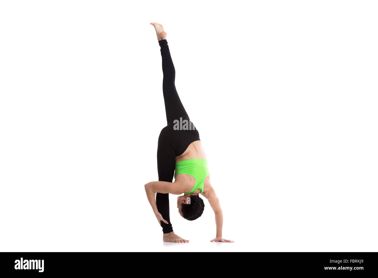 Slim sporty girl on white background bending forward in standing split yoga asana, urdhva prasarita eka padasana Stock Photo