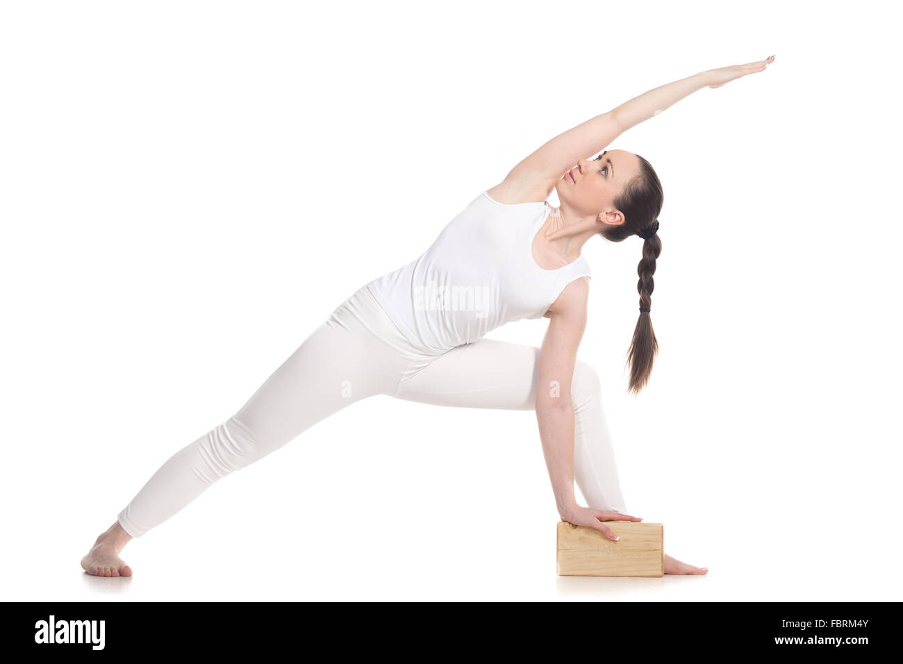 Sporty attractive young beginning yoga woman student in white sportswear doing lunge exercise for spine, utthita parsvakonasana Stock Photo