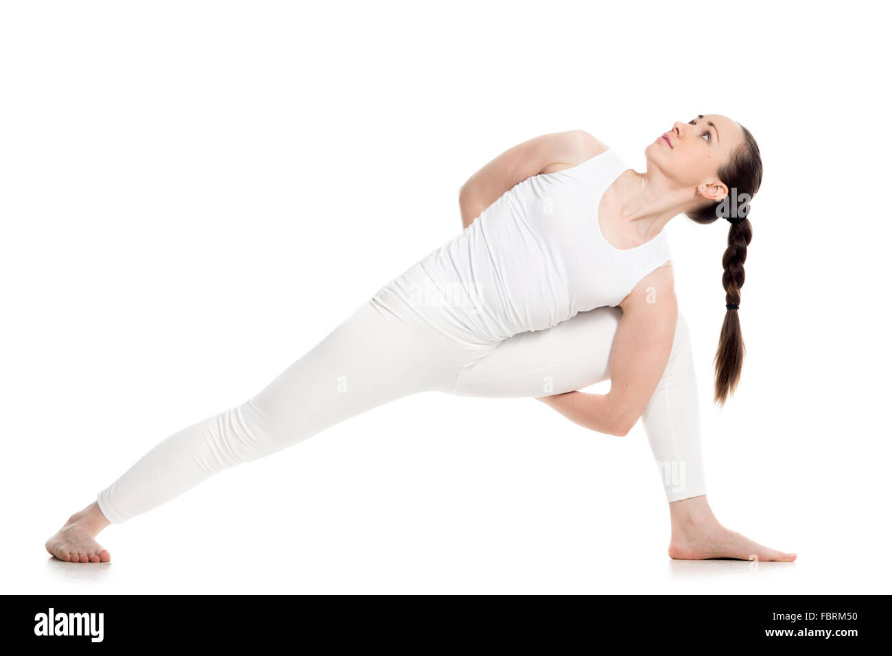 Sporty attractive young woman in white sportswear doing lunge exercise for spine, variation of utthita parshvakonasana Stock Photo