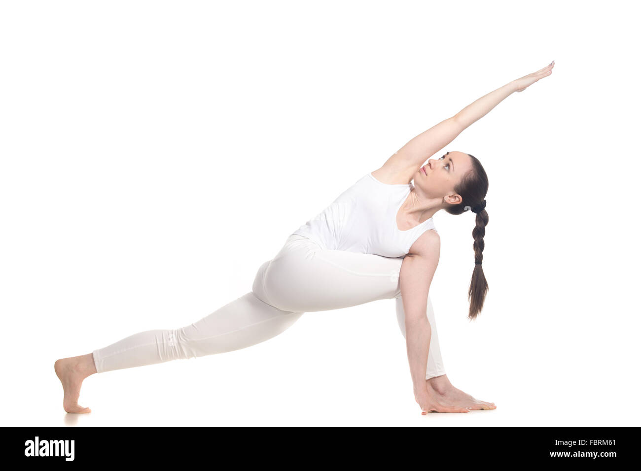 Sporty beautiful young woman in white sportswear doing lunge exercise for spine flexibility, standing in parivritta parshvakonas Stock Photo