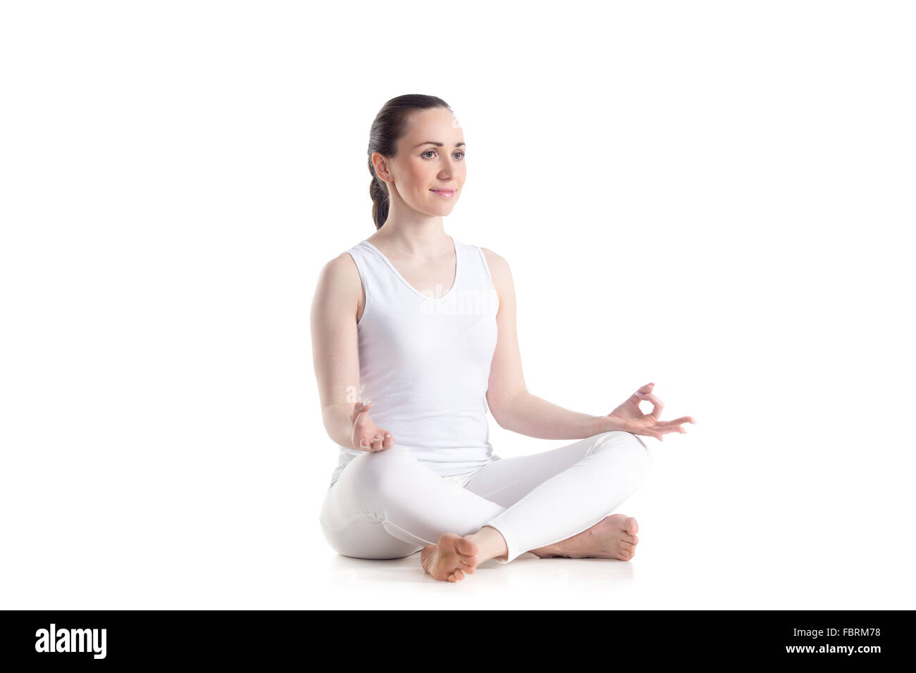 Sporty beautiful young woman practicing yoga, Sitting in Easy (Decent, Pleasant Pose), Sukhasana, asana for meditation Stock Photo