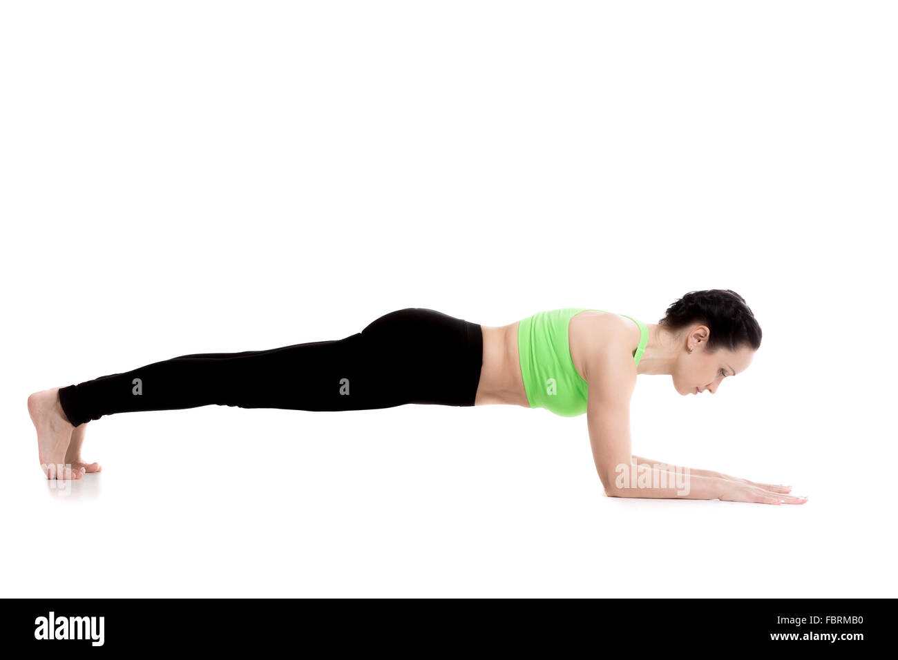 Sporty girl doing Dolphin Plank exercise, modification of Phalankasana (Plank Pose), training for core muscles, arms and thighs Stock Photo