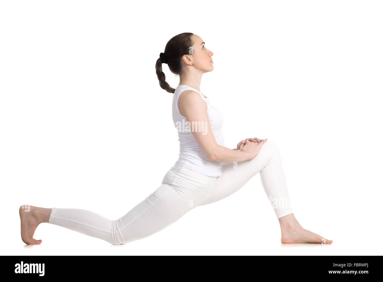 Sporty beautiful young woman in white sportswear doing low lunge ...