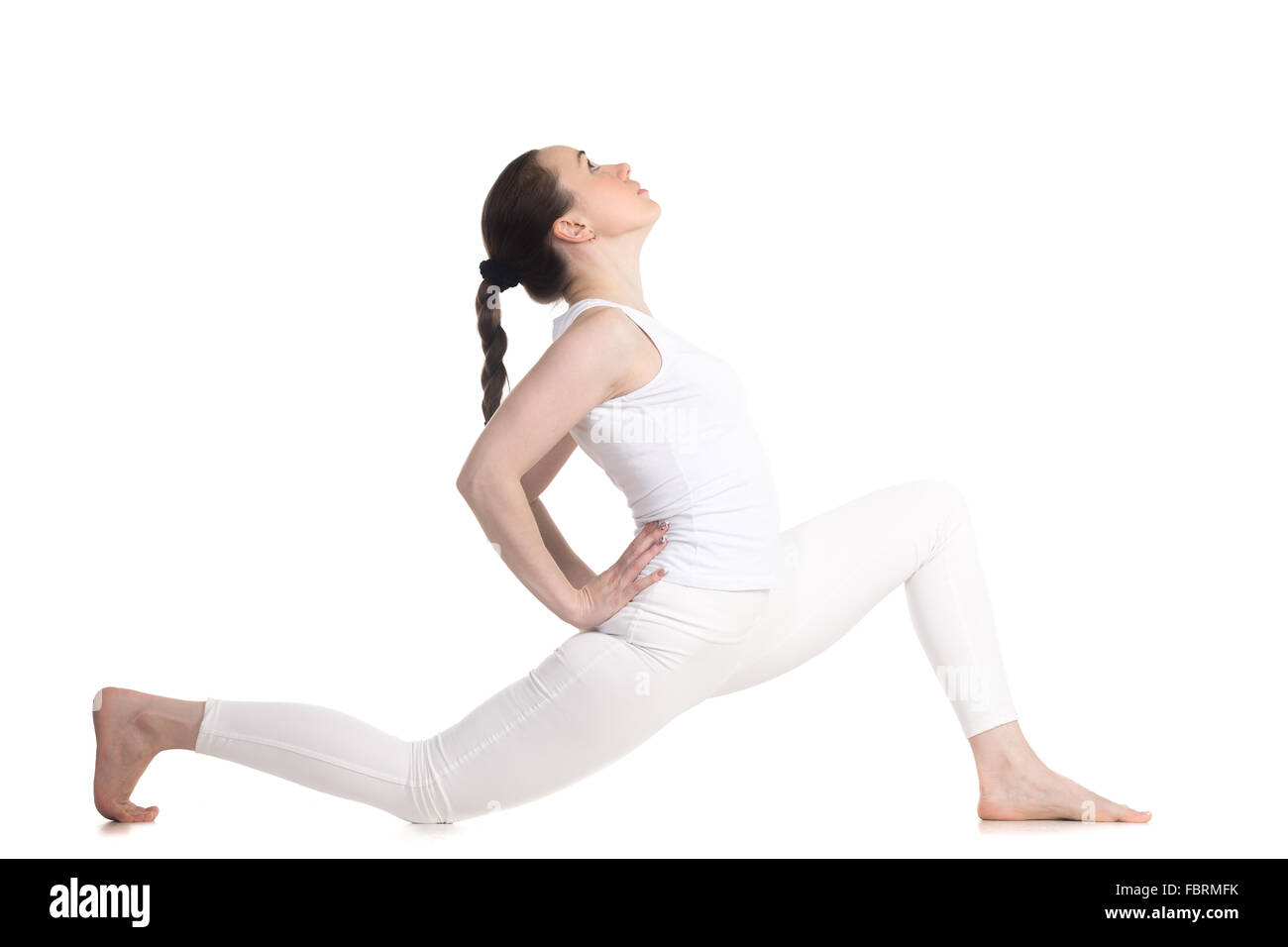 Sporty beautiful young woman in white sportswear doing low lunge ...