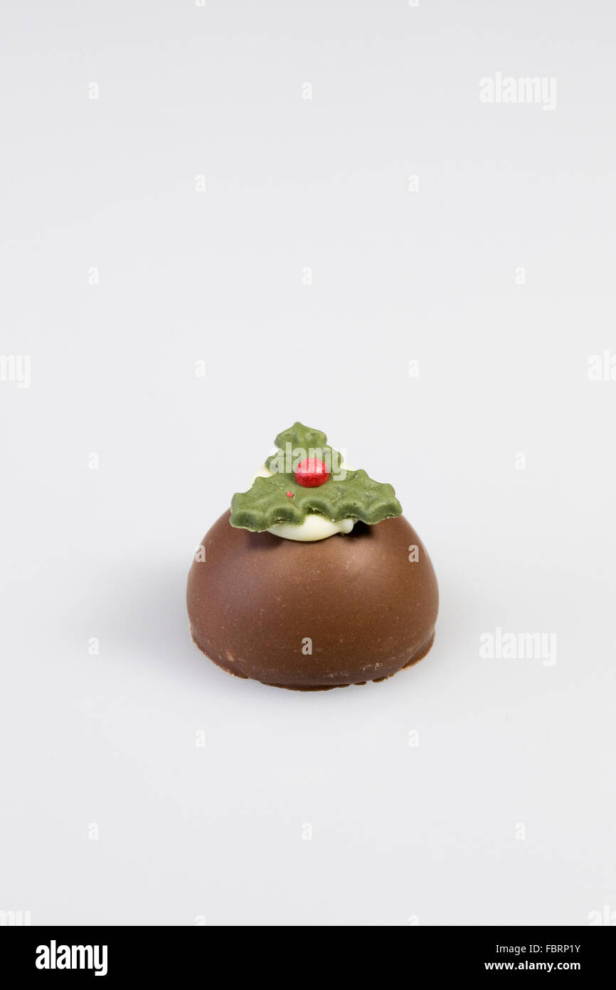 A single chocolate christmas pudding on a white background. Stock Photo