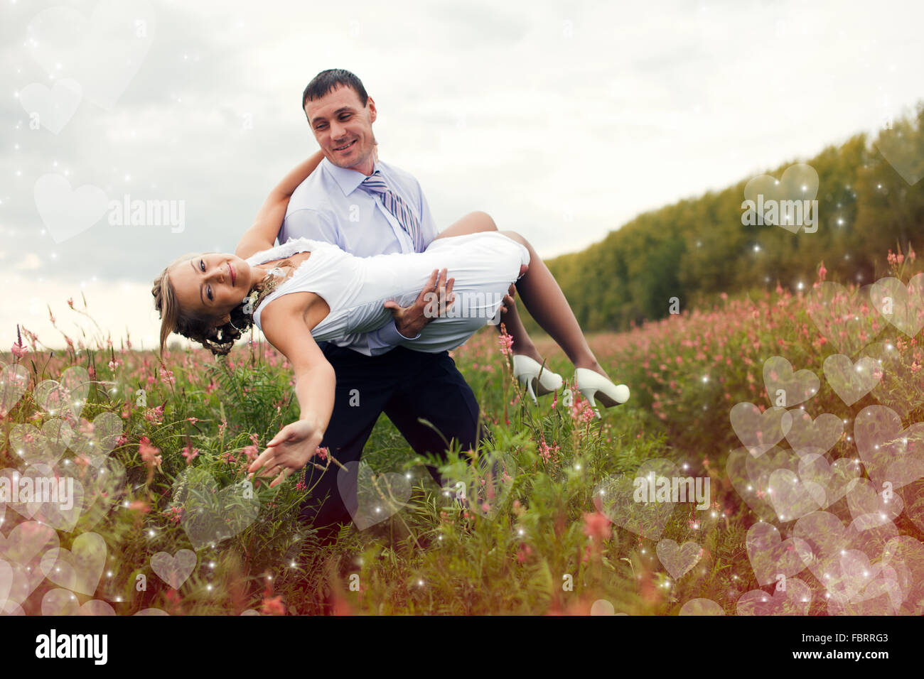 Husband is holding his bride on hands Stock Photo