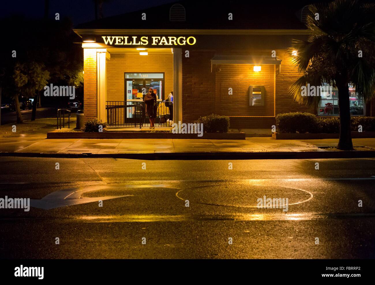 The lights of a Wells Fargo branch reflecting in the street wet with rain in Pacific Beach, in January 2016. Stock Photo