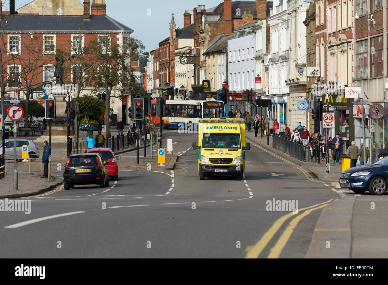 Ambulance responding to emergency with blue lights on in the High Street in Bedford, Bedfordshire, England Stock Photo