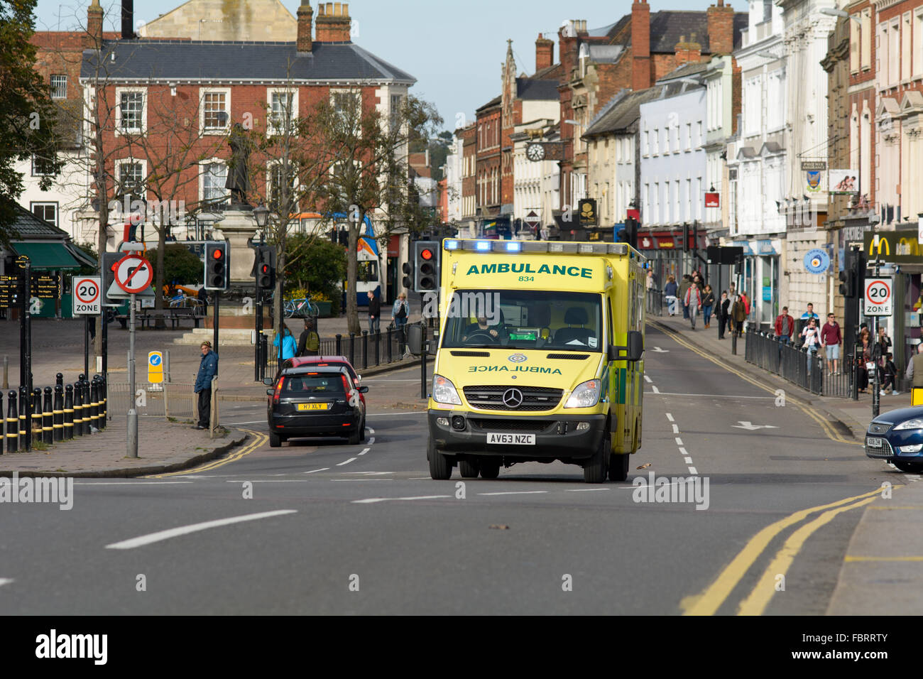 Ambulance responding to emergency with blue lights on in the High Street in Bedford, Bedfordshire, England Stock Photo