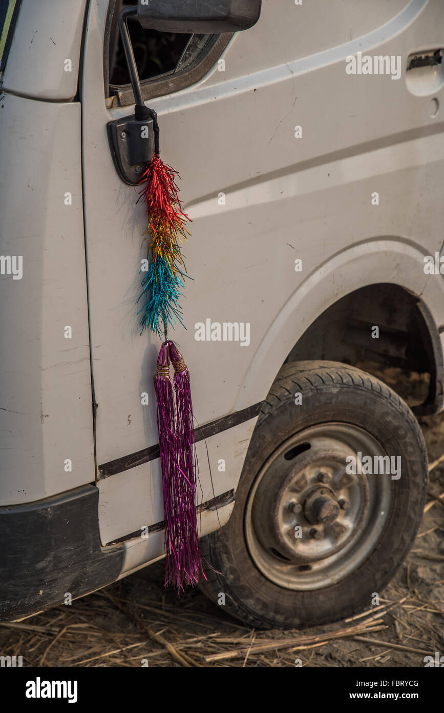 Detail of white van door, wing mirror and hanging sparkling tinsel. Close up. Typically Indian. Assam, India. Stock Photo