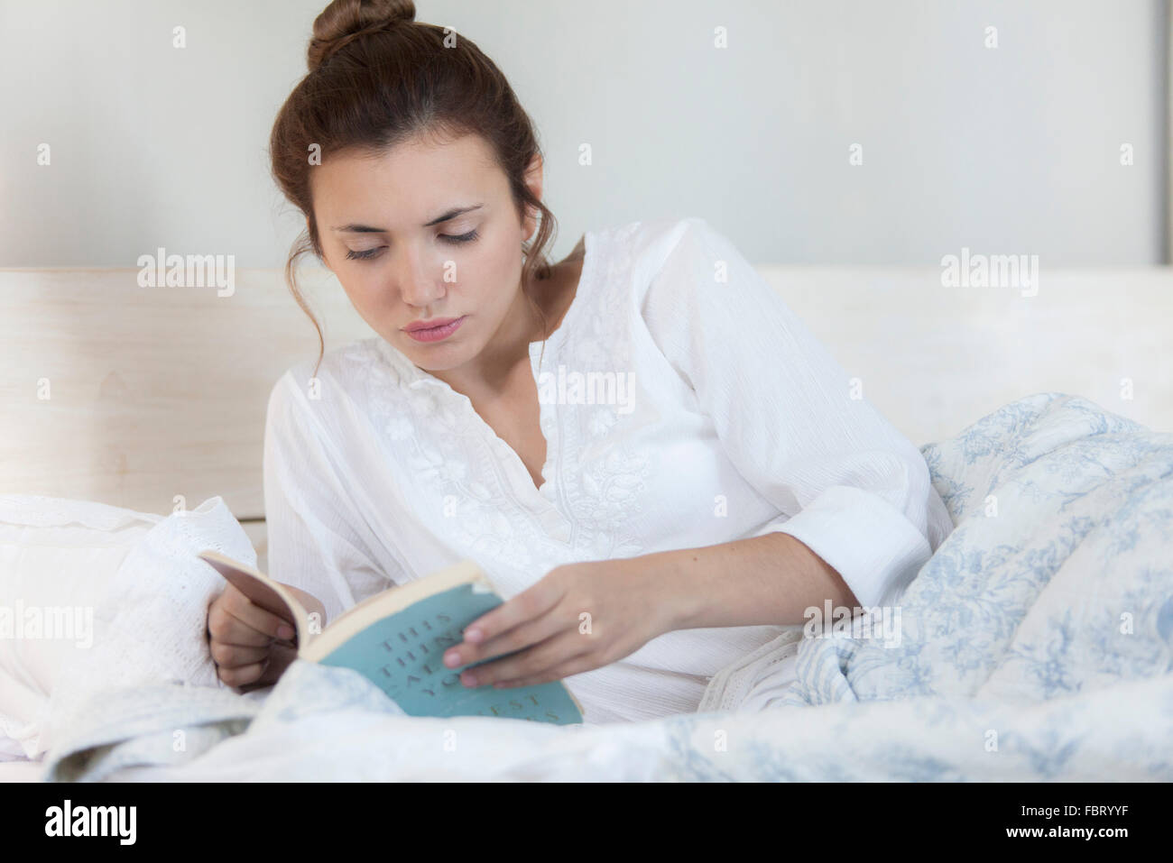 Woman reading in bed Stock Photo