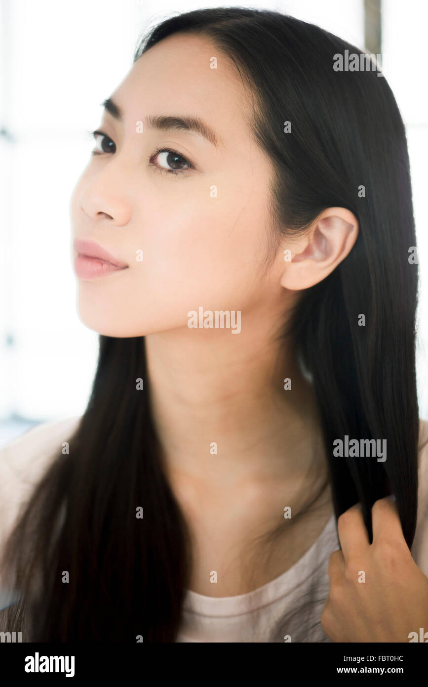 Woman running fingers through ends of hair Stock Photo Alamy