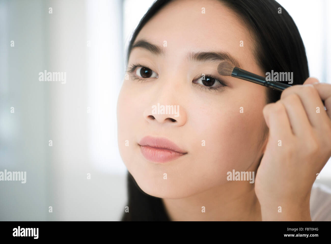 Woman applying eye shadow Stock Photo