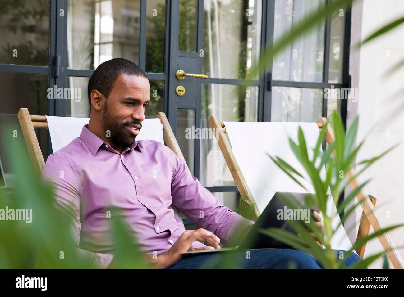 Businessman sitting deck chair laptop hi-res stock photography and ...
