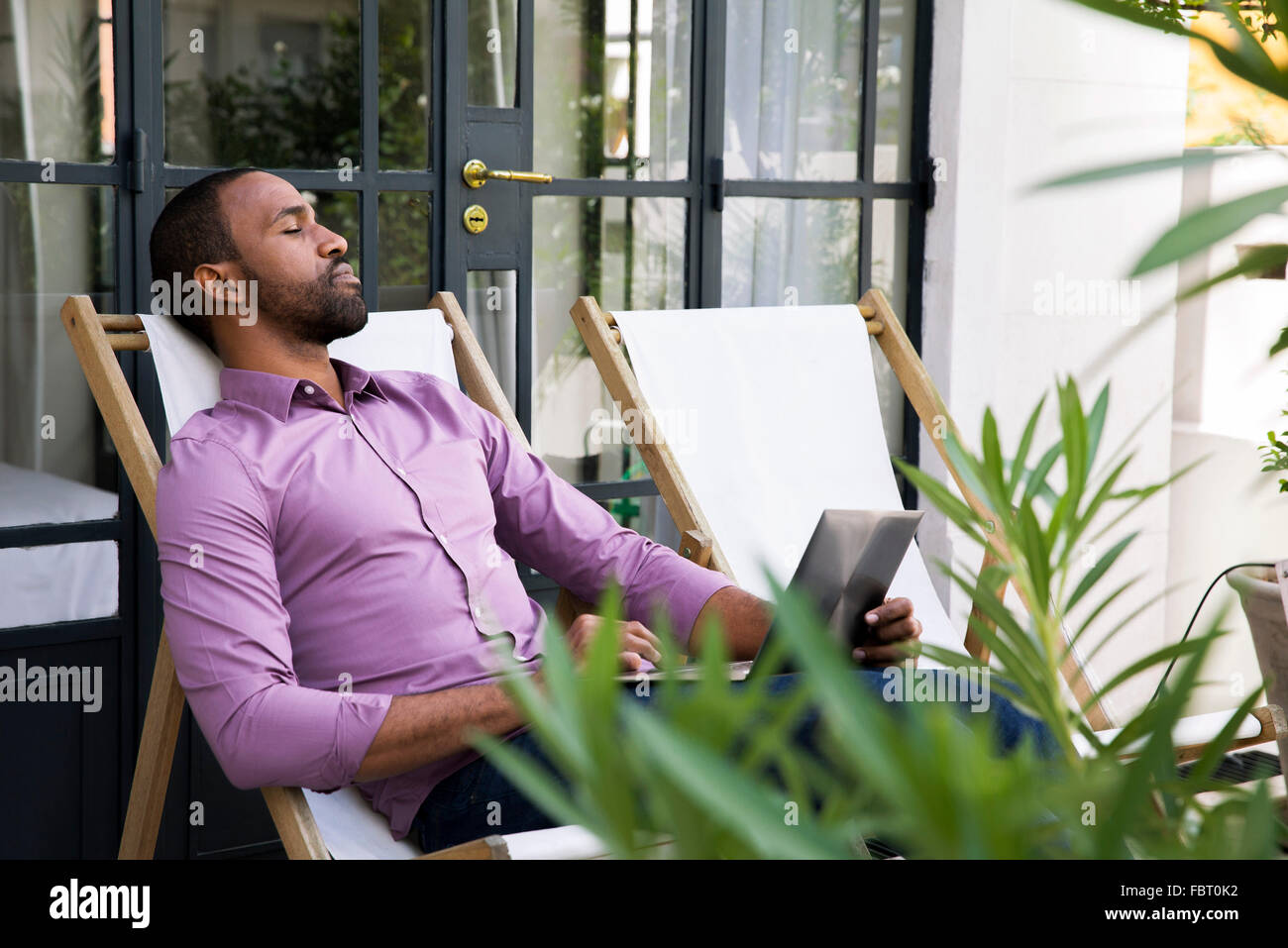 Man napping in deckchair Stock Photo