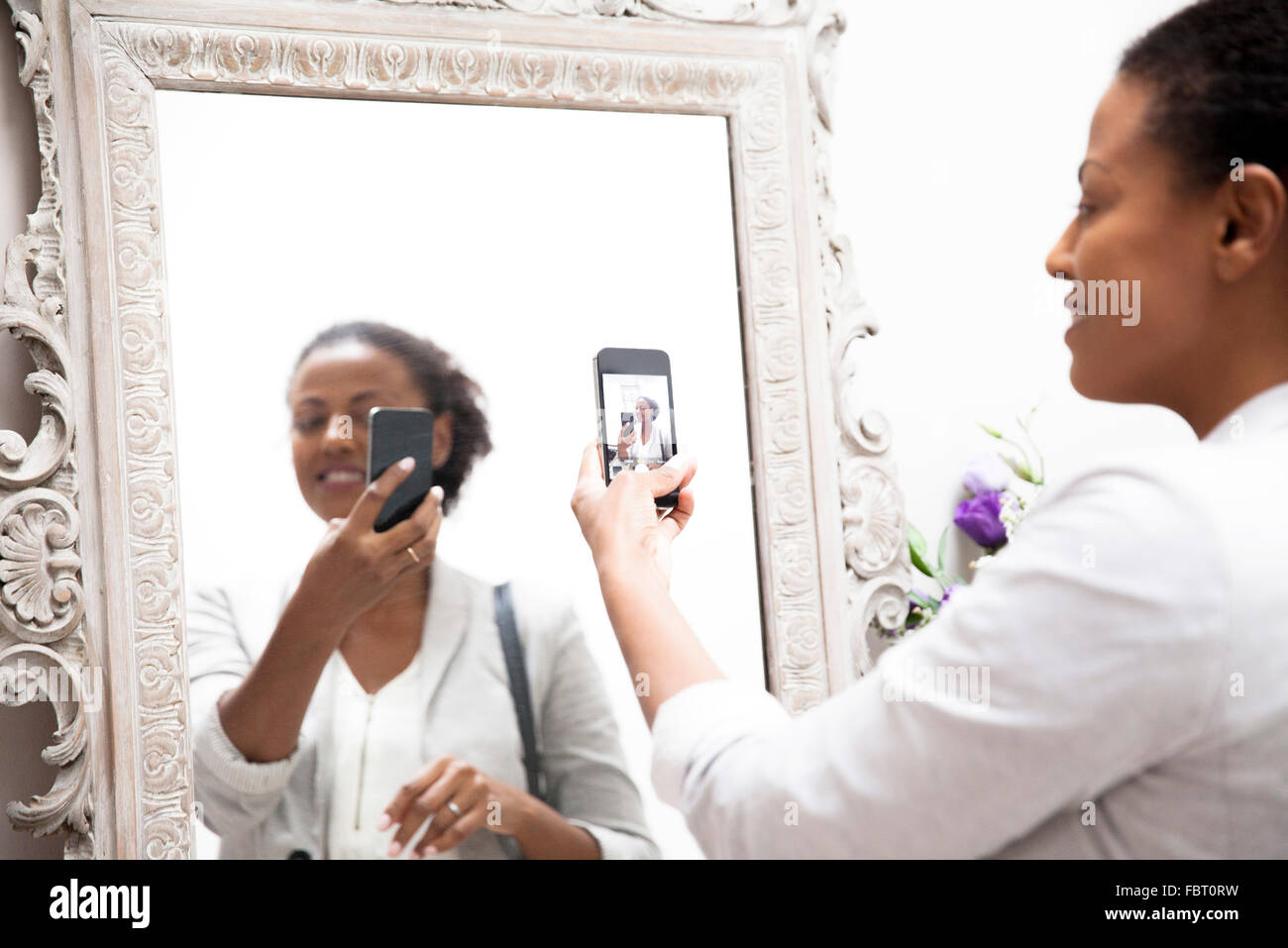 Woman taking selfie in mirror Stock Photo